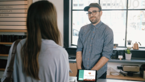 Coffee shop employee showing rewards program