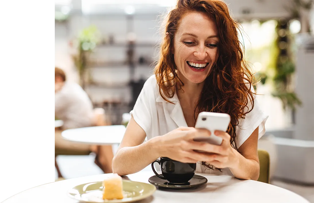 Smiling guest at a café using her phone