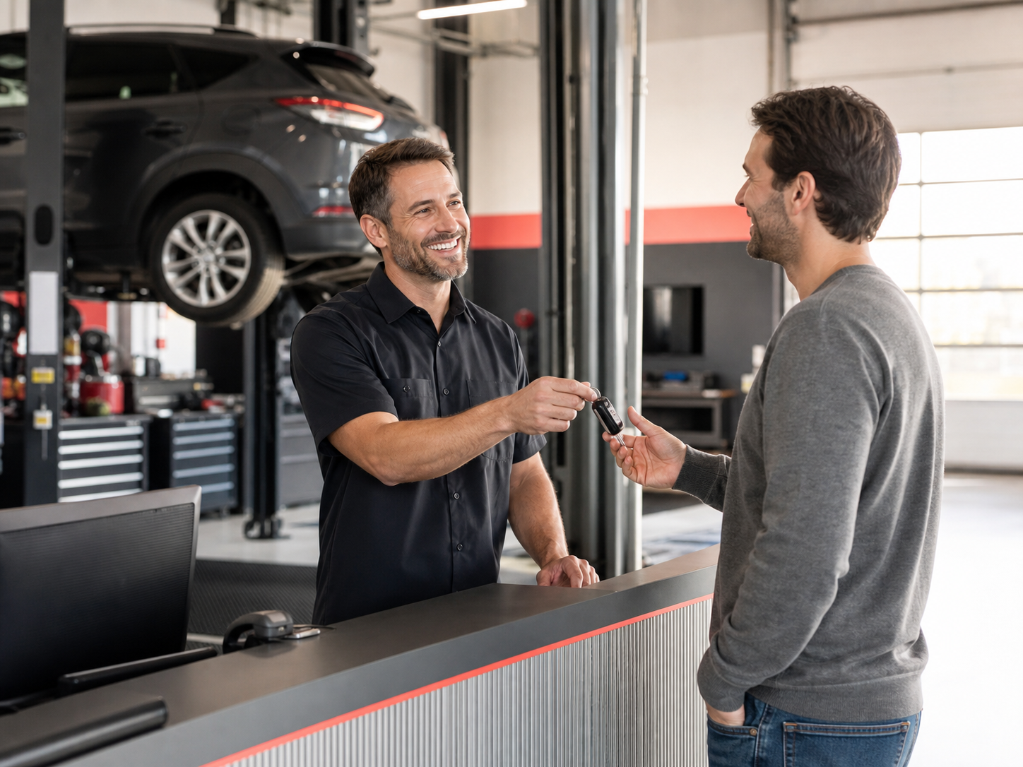 An auto shop owner handing a customer their keys